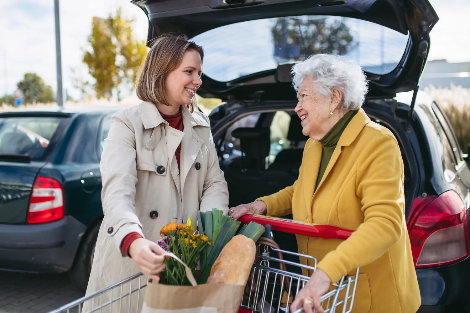 Curanus GmbH – Pflege – Enkelin hilft Großmutter beim Einladen Lebensmittel ins Auto.