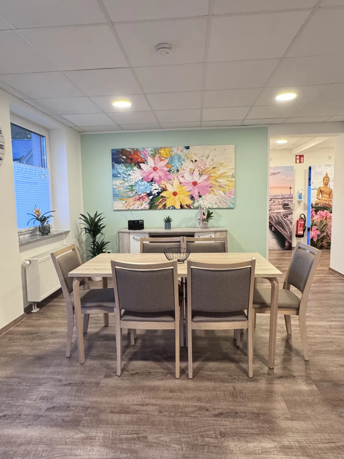 Curanus GmbH – Pflege – Szene: Familie hält die Hände eines sterbenden älteren Patienten, der mit Sauerstoff und Infusion im Bett liegt.